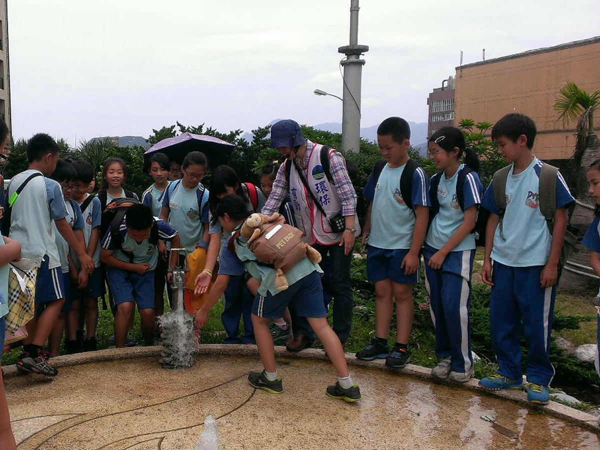 國小學生參訪「海大雨水公園」雨水利用景觀區，觀察與體驗「手壓幫浦」將雨水有效收集並現地利用情形